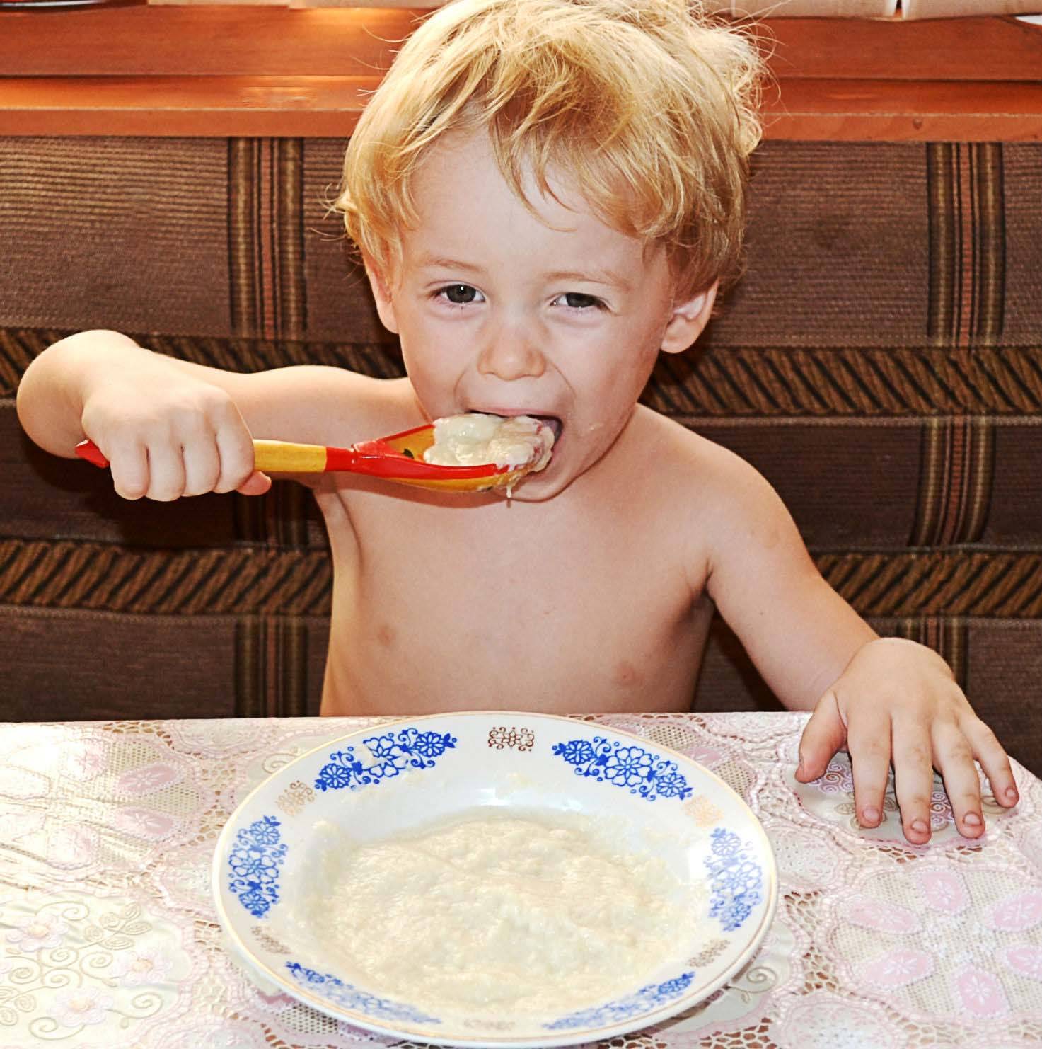 Кашка года. Мальчик ест кашу. Кушать кашу. Ребенок завтракает. Дети за столом.