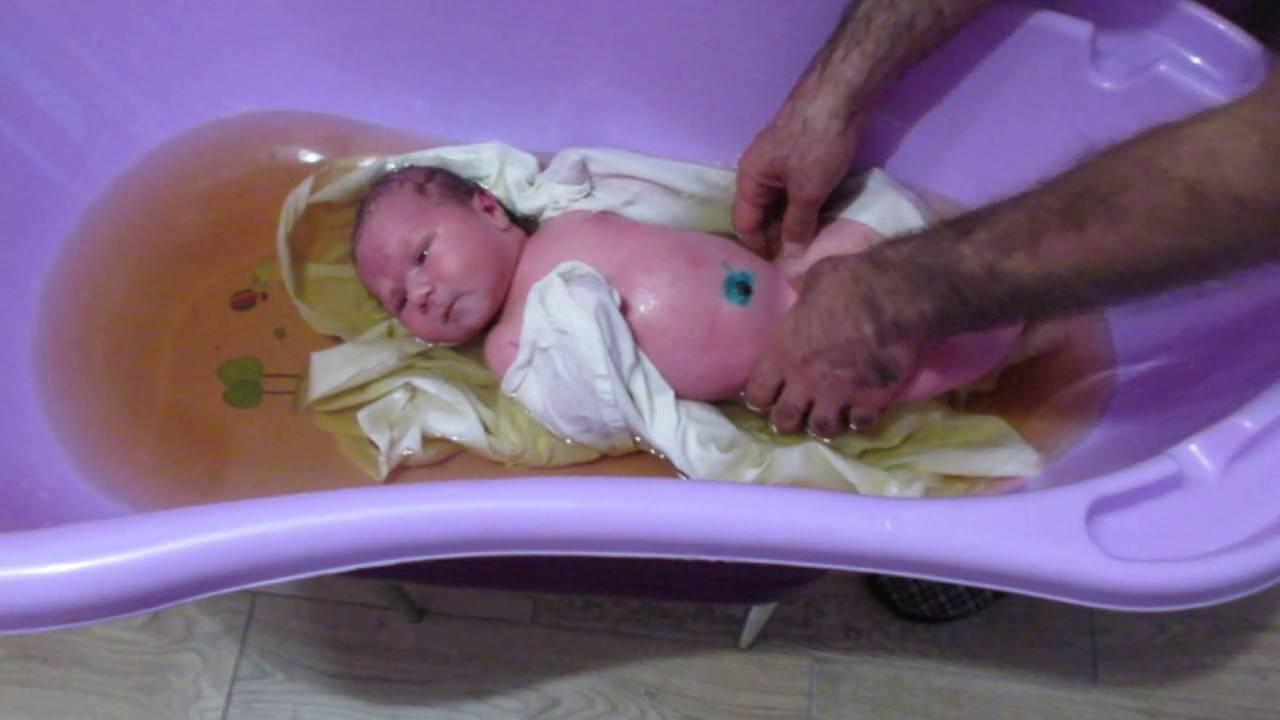 Новорожденный ребенок первое купание. Купание новорожденного ребенка. Купание новорожденного ребенка в ванночке. Купание малыша после роддома. Купание новорожденных детей после роддома.