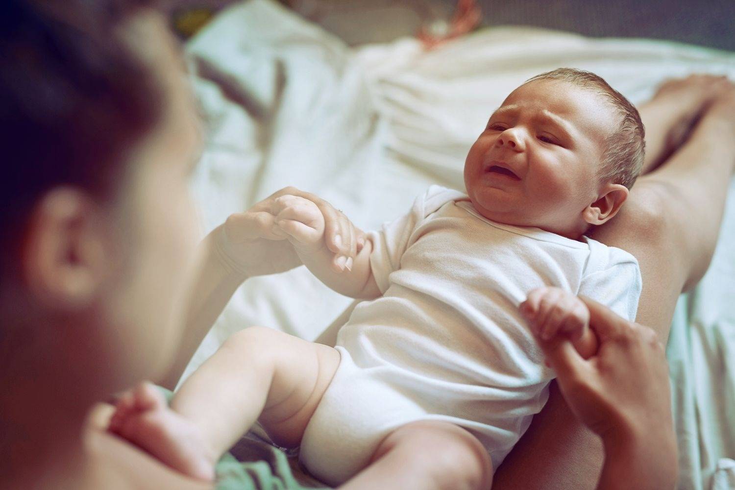 Новорожденный малыш кряхтит во сне, постоянно тужится и стонет: почему это происходит и что делать?